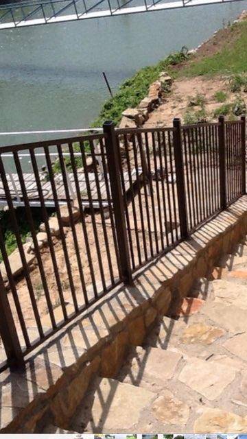 Ornamental iron fence along a riverside stone step path in Wise County