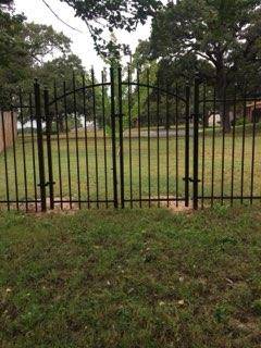 Black arched double ornamental iron entry gate in Decatur, TX