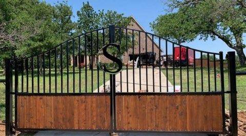 Custom driveway gate with a monogram medallion built for a Decatur, TX ranch